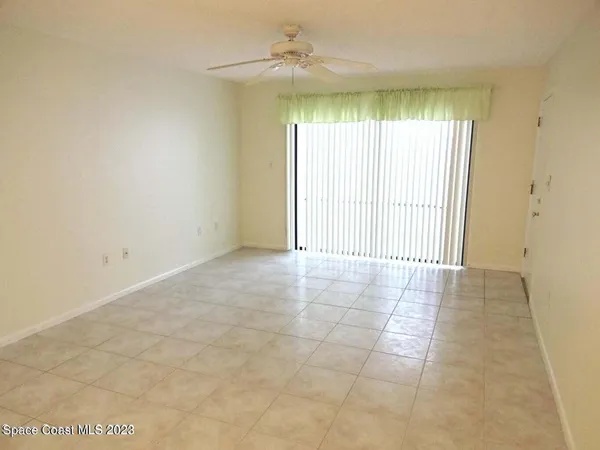 an empty room with windows and ceiling fan