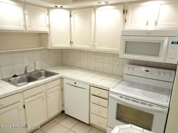 a kitchen with white cabinets and white appliances