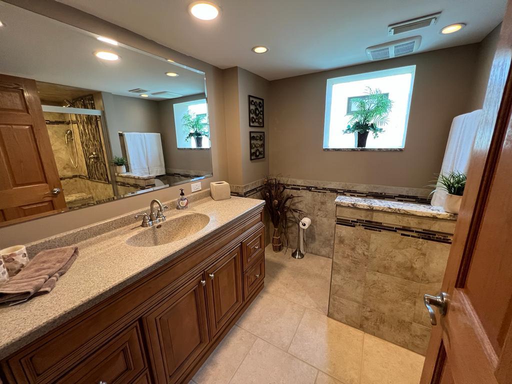4031 Custer Avenue Lyons, IL 60534 - Photo 18 of 38 a bathroom with a double vanity sink a mirror and a bathtub