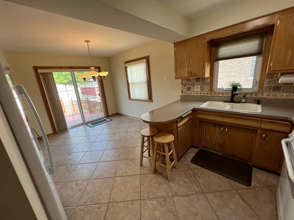 4031 Custer Avenue Lyons, IL 60534 - Photo 9 of 38 a kitchen with a sink a counter top space and cabinets