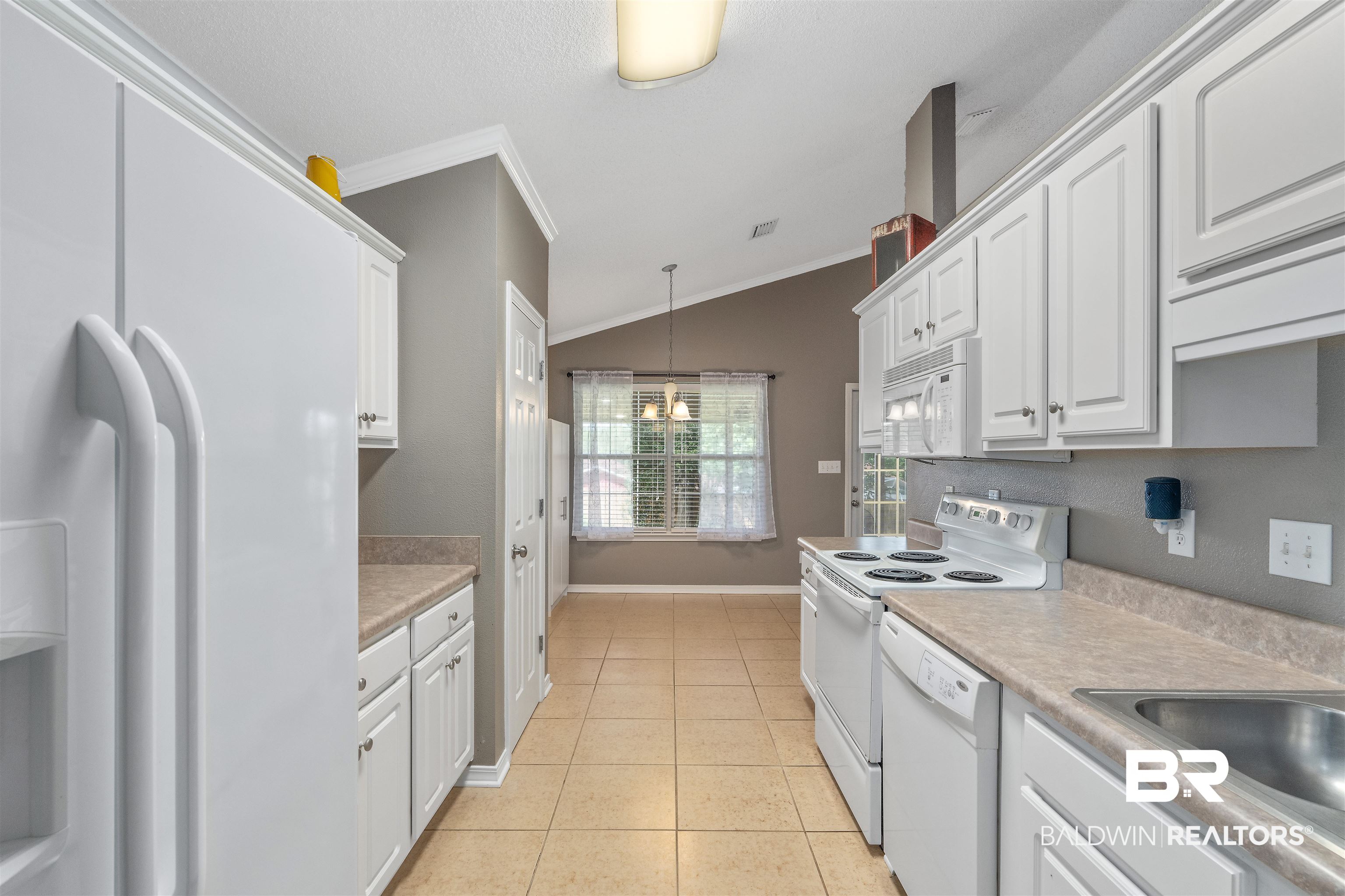 11097 Pontchartrain Loop Daphne, AL 36526 - Photo 11 of 28 Kitchen with white appliances, ornamental molding, white cabinetry, light countertops, and light tile patterned floors