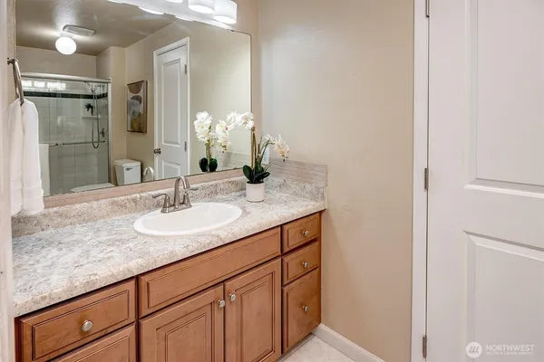 a bathroom with a granite countertop sink and a mirror