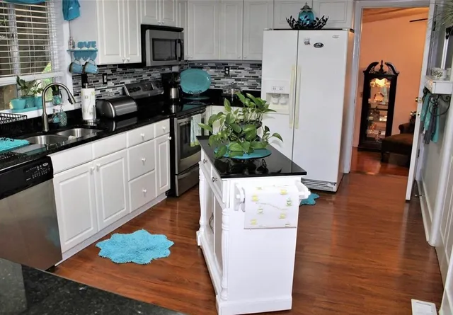a kitchen with sink a refrigerator and a stove