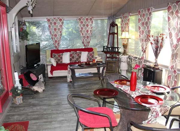 an outdoor living room with furniture and a floor to ceiling window