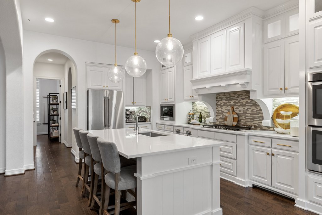 8801 Wild Rice Cove Austin, TX 78738 - Photo 12 of 40 Statement pendants illuminate the oversized island, while canned lights allow you to tailor your lighting atmosphere.