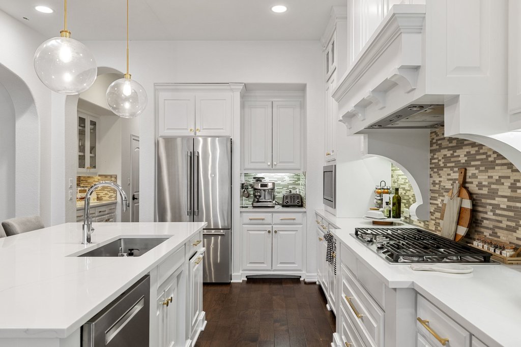 8801 Wild Rice Cove Austin, TX 78738 - Photo 13 of 40 Featuring sleek quartz countertops, tiled backsplash, and built-in stainless steel appliances.