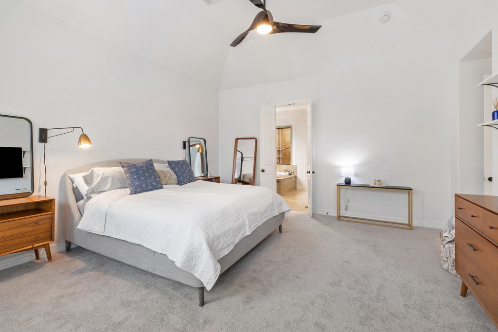 8801 Wild Rice Cove Austin, TX 78738 - Photo 19 of 40 Featuring tall ceilings, a modern LED ceiling fan, comfortable carpeting, and ample space for a king sized bed, furniture, and seating area.