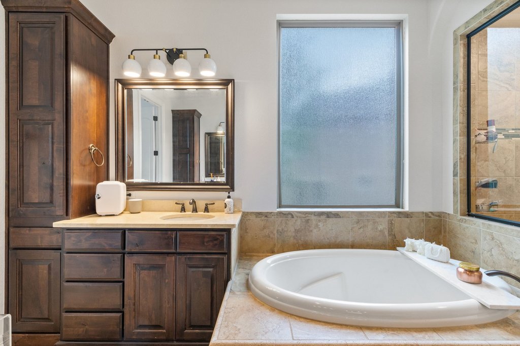 8801 Wild Rice Cove Austin, TX 78738 - Photo 21 of 40 Featuring a relaxing soaking tub and a large walk-in shower, both with tasteful tile surround.
