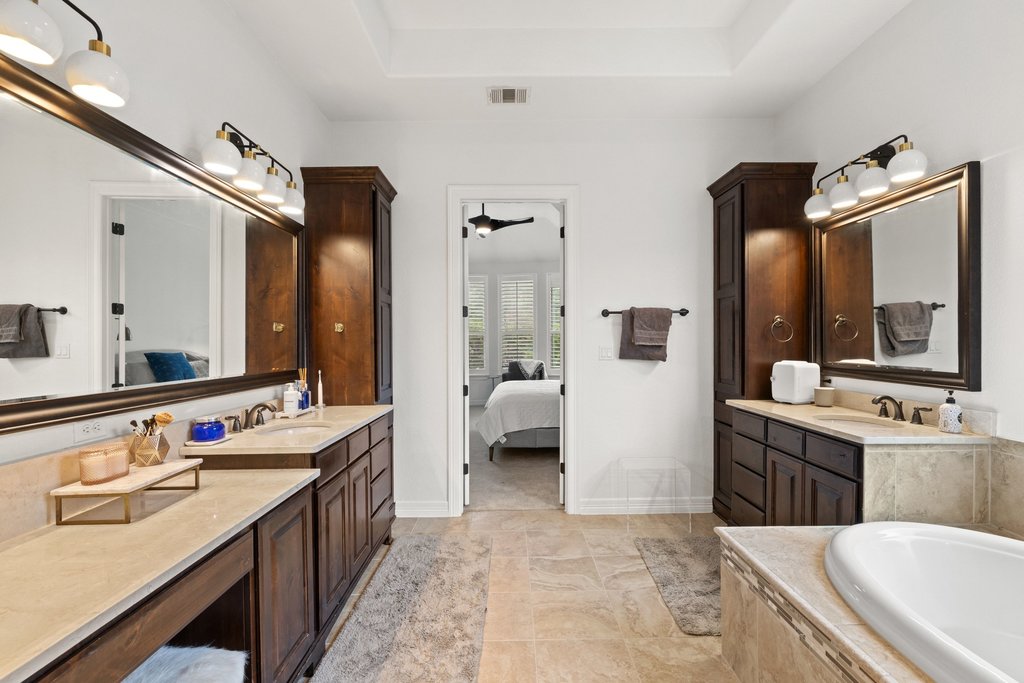 8801 Wild Rice Cove Austin, TX 78738 - Photo 22 of 40 Separate vanities come with rich wood cabinetry and excellent built-in storage.