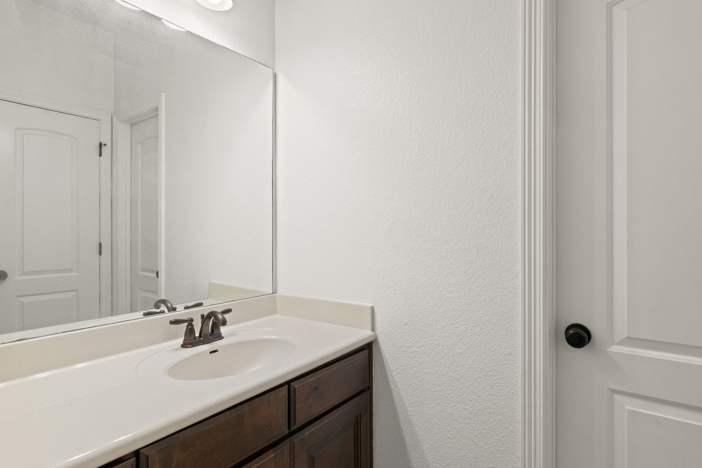 8801 Wild Rice Cove Austin, TX 78738 - Photo 30 of 40 Two of the secondary bedrooms share a jack-n-jill ensuite bath, each with their own vanity area that connects to the shared wet room.
