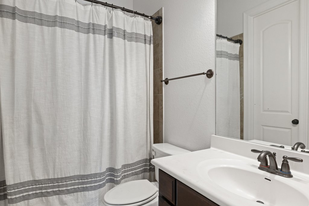 8801 Wild Rice Cove Austin, TX 78738 - Photo 33 of 40 Another full secondary bathroom upstairs comes with a shower/tub combo with tile backsplash.