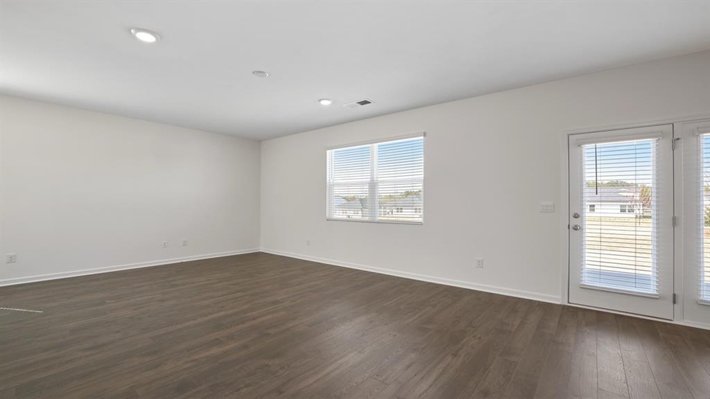 8580 Seabiscuit Road Lithonia, GA 30058 - Photo 11 of 37 an empty room with wooden floor and windows