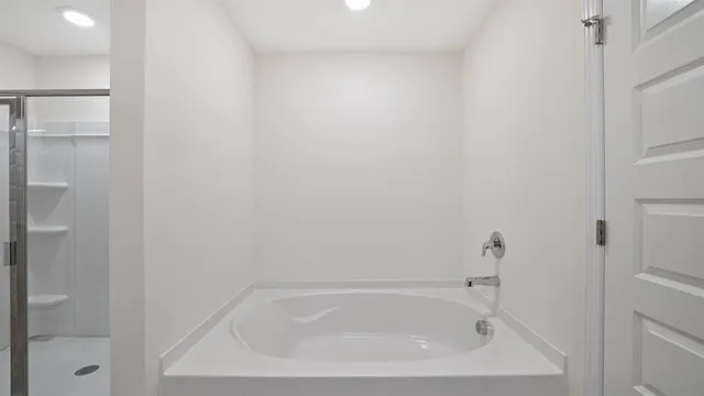 a white bath tub sitting next to a white sink and vanity