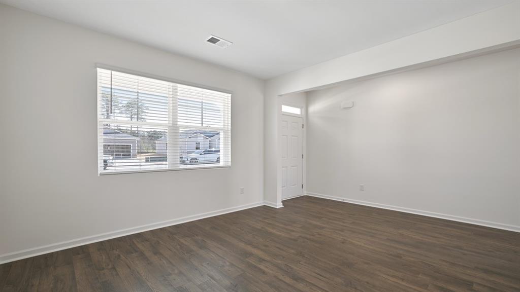 8580 Seabiscuit Road Lithonia, GA 30058 - Photo 2 of 37 a view of an empty room with wooden floor and a window