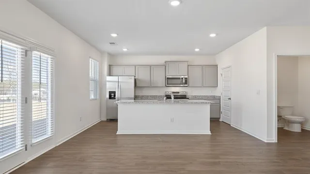 a view of a kitchen with kitchen island a sink a counter top space and appliances