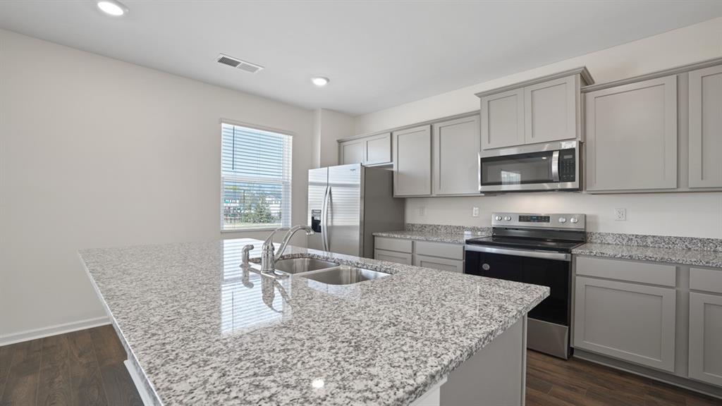 8580 Seabiscuit Road Lithonia, GA 30058 - Photo 5 of 37 a kitchen with stainless steel appliances granite countertop a sink stove microwave and refrigerator