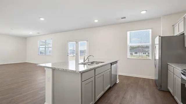 a kitchen with stainless steel appliances granite countertop a sink stove and refrigerator