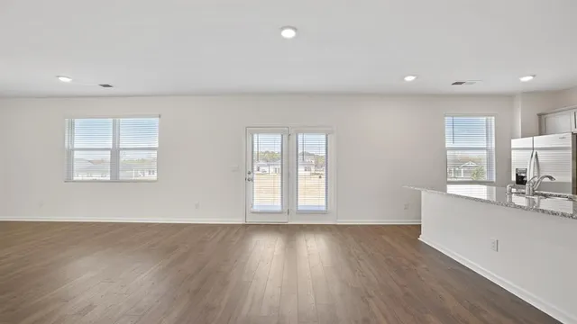 a view of a kitchen with wooden floor and electronic appliances
