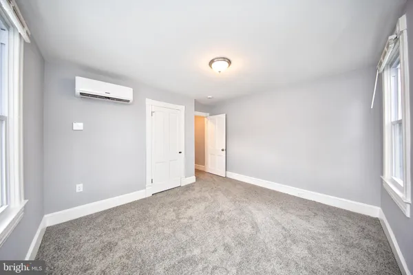an empty room with windows and closet