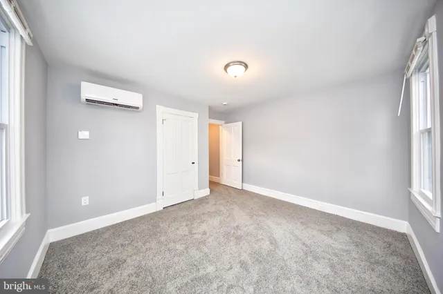 an empty room with windows and closet