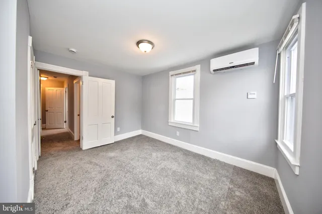 an empty room with windows and closet