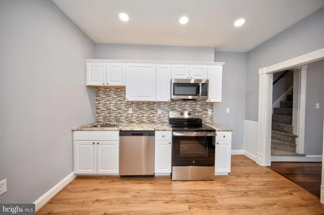 a kitchen with stainless steel appliances granite countertop a stove top oven a sink and a granite counter tops