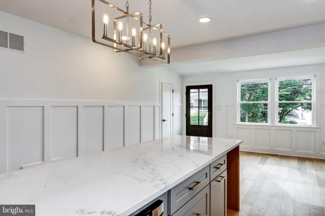 a view of a kitchen with a chandelier fan and wooden floor