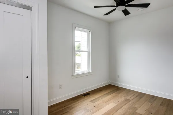 an empty room with a window and a fan