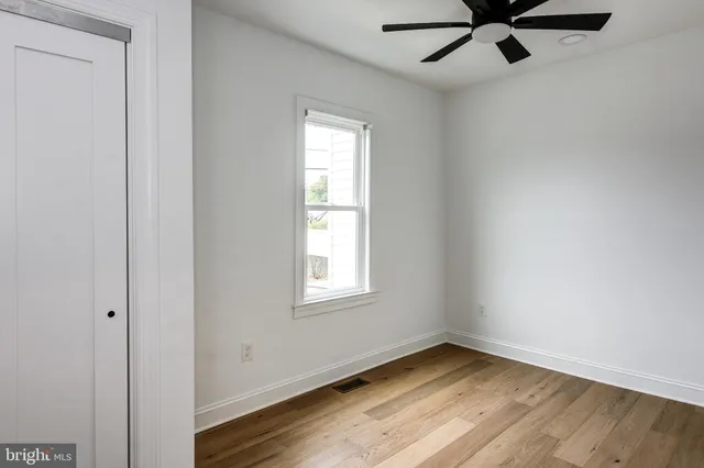 an empty room with a window and a fan