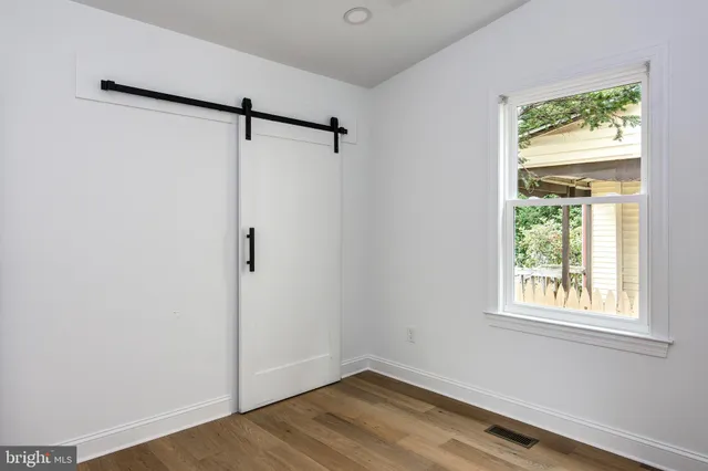 a view of a room with wooden floor and windows