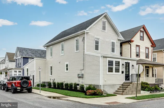 a front view of a house with a garden and parking