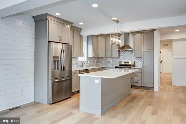 a kitchen with stainless steel appliances a refrigerator and a stove top oven
