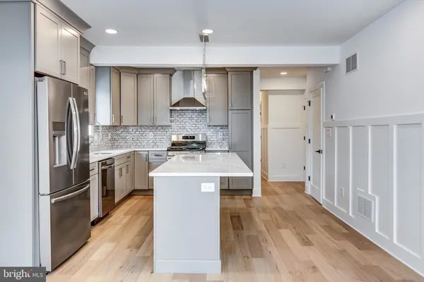 a kitchen with kitchen island a stove a refrigerator and a oven