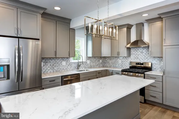 a kitchen with stainless steel appliances a sink stove and refrigerator