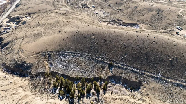 a view of a dry yard with mountains in the background