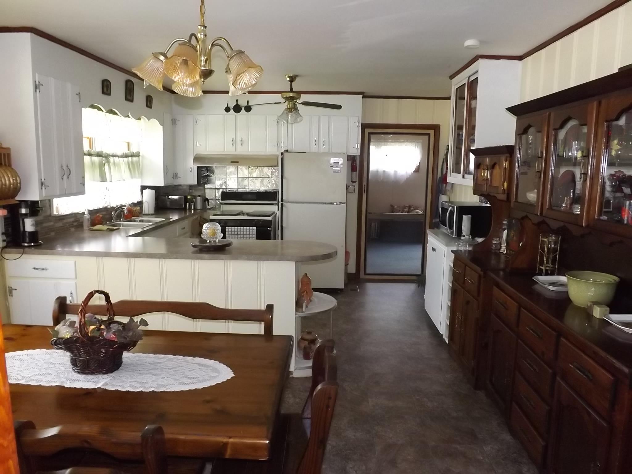81 Shelton Road Manchester, TN 37355 - Photo 8 of 15 a kitchen with stainless steel appliances granite countertop a sink dishwasher a stove a refrigerator a dining table and chairs with wooden floor
