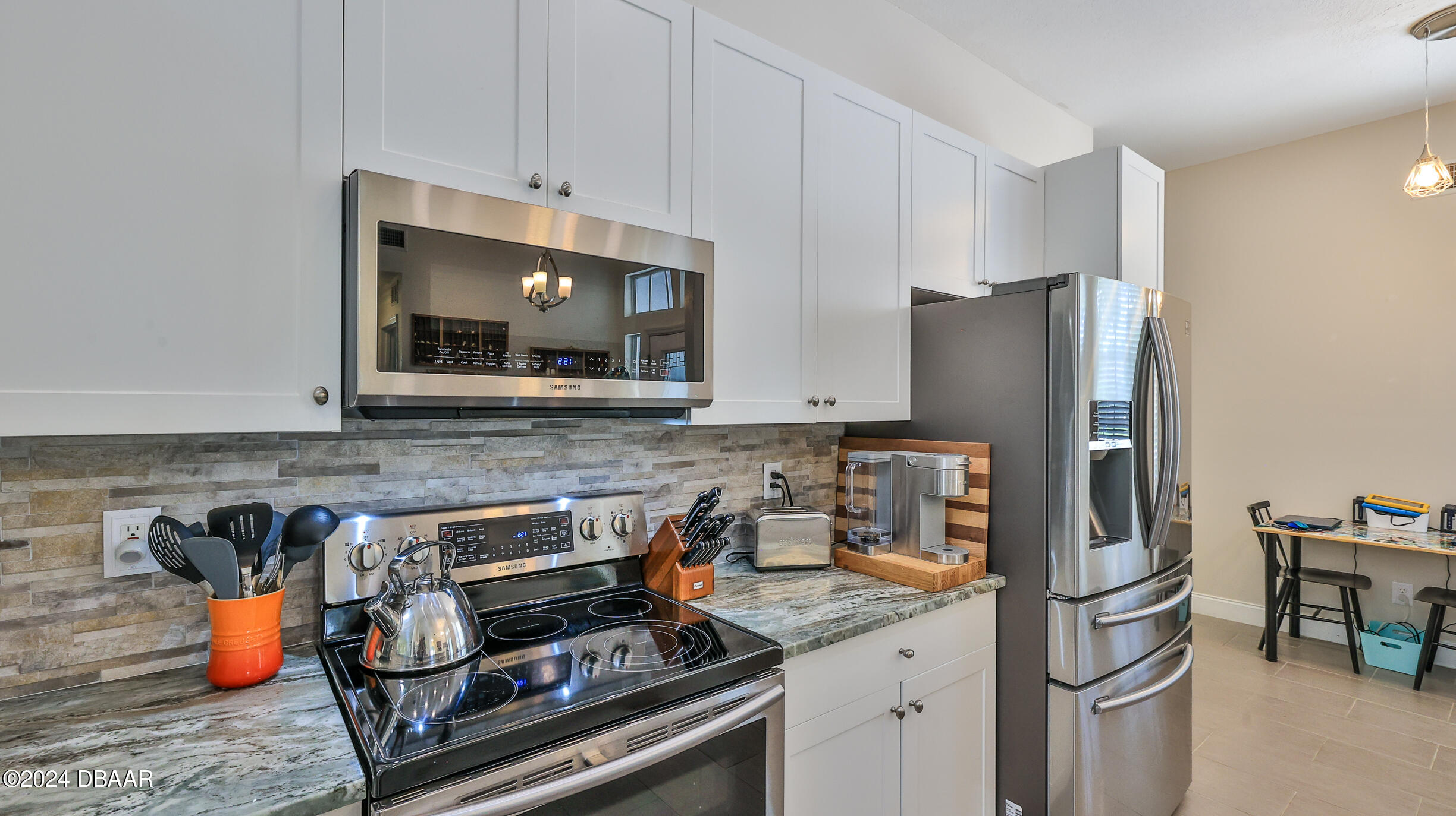 16 Meadow Ridge View Ormond Beach, FL 32174 - Photo 11 of 45 a kitchen with stainless steel appliances granite countertop a stove refrigerator and microwave
