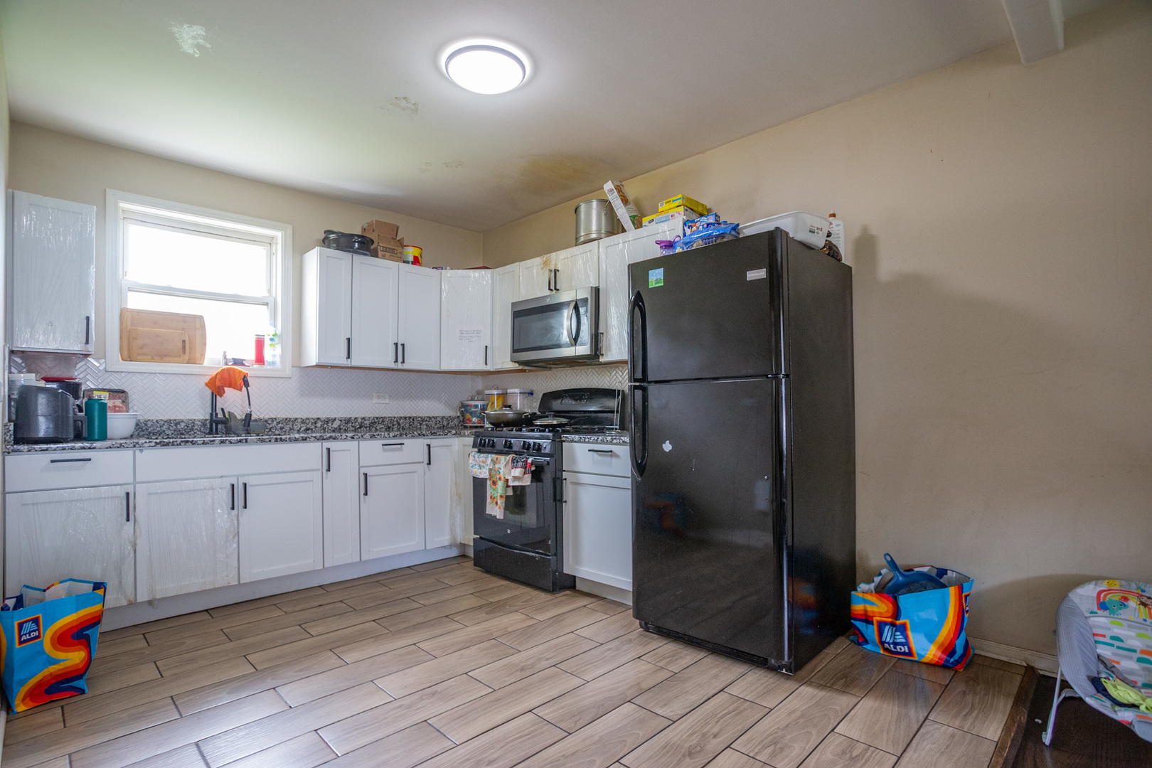 9226 South Ellis Avenue Chicago, IL 60619 - Photo 6 of 17 a kitchen with granite countertop stainless steel appliances a refrigerator and a sink