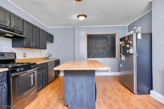 a kitchen with stainless steel appliances kitchen island a refrigerator sink and stove