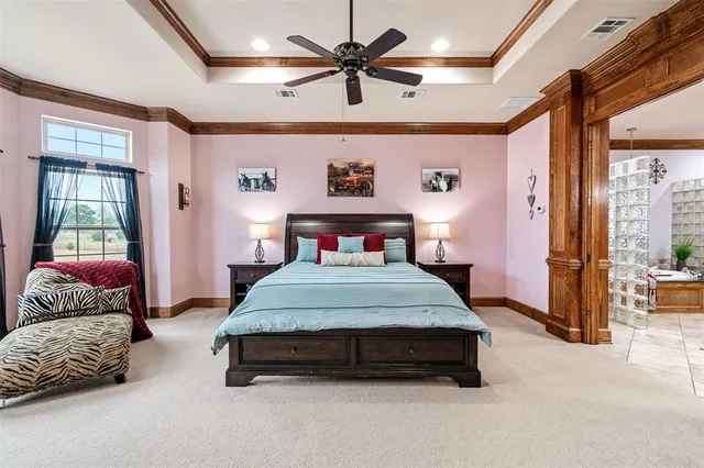 a bedroom with a bed couch chandelier and a window