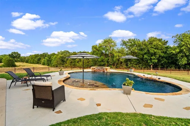 an aerial view of a house with swimming pool and garden