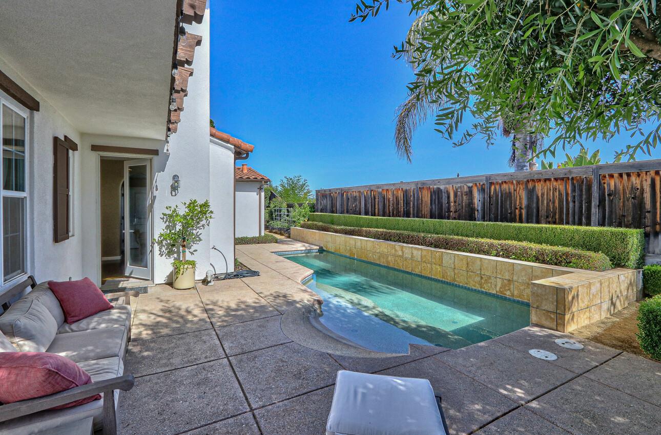 7260 Eagle Ridge Drive Gilroy, CA 95020 - Photo 32 of 36 a view of a backyard with couches and a lawn chairs under an umbrella