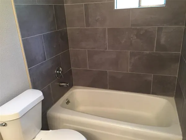 a bathroom with a bathtub and toilet
