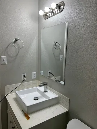 a bathroom with a sink mirror and toilet