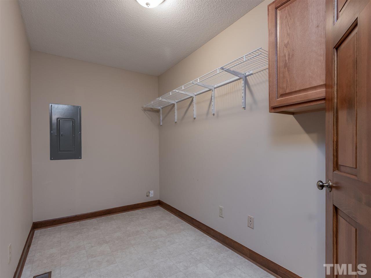 8701 Brandon Station Road Raleigh, NC 27613 - Photo 22 of 30 Oversized laundry room with washer and dryer closet, cabinet and shelving storage. Great space for additional storage and a laundry folding table.