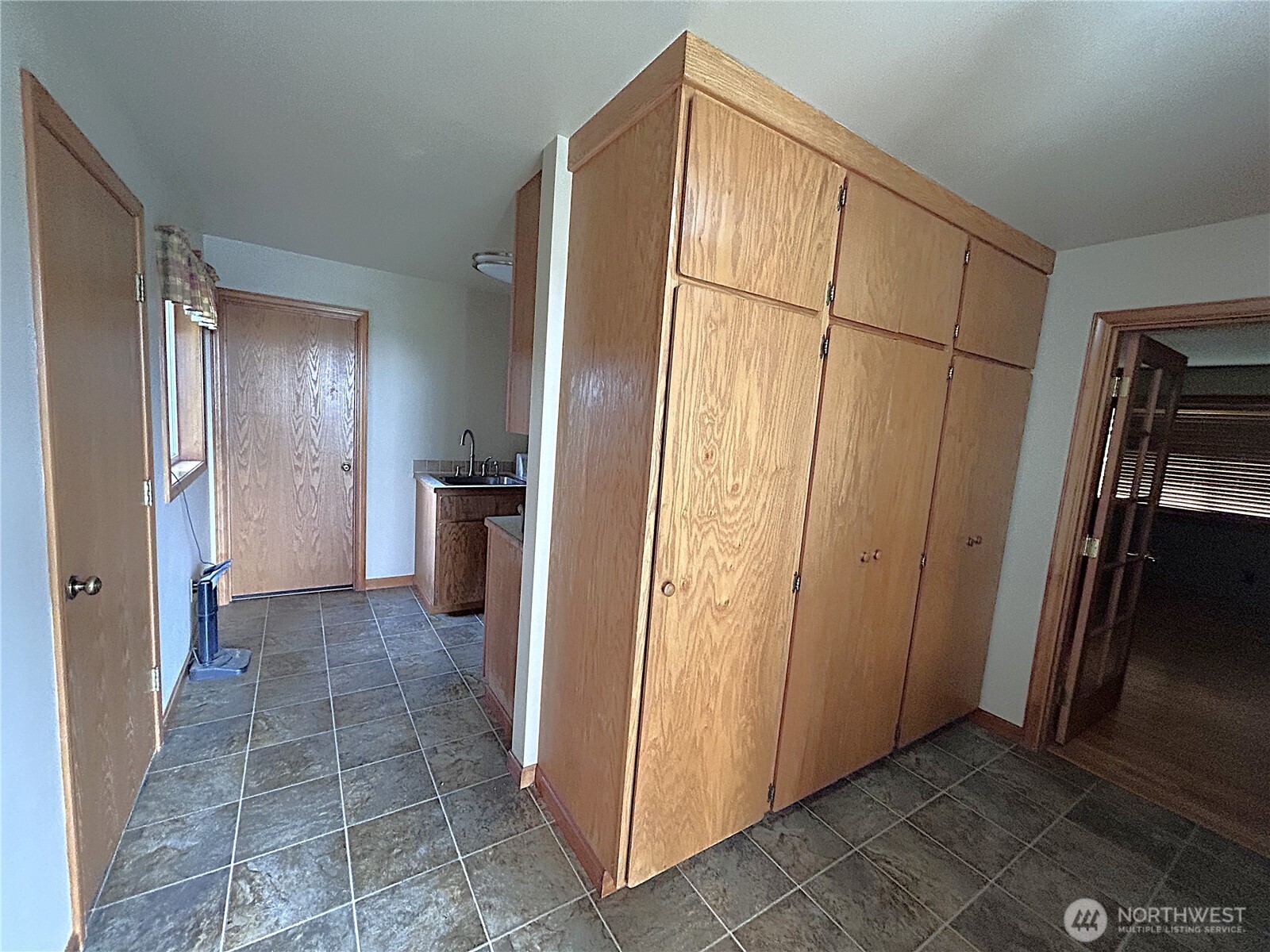 1925 Hampton Road Everson, WA 98247 - Photo 6 of 40 a view of a refrigerator in kitchen and an empty room in wooden floor