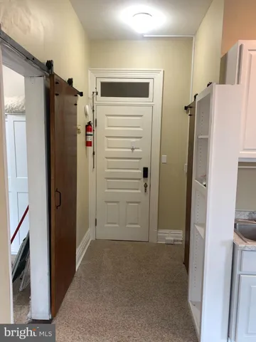 a view of hallway with a refrigerator and a stove