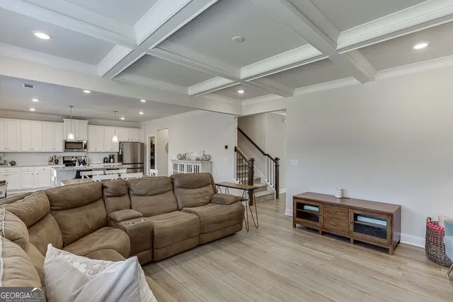 a living room with furniture a wooden floor and a ceiling fan