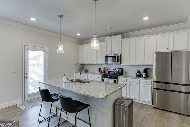 a kitchen with granite countertop a center island and stainless steel appliances