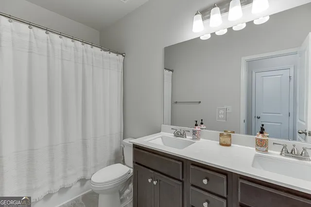 a bathroom with a double vanity sink mirror and toilet